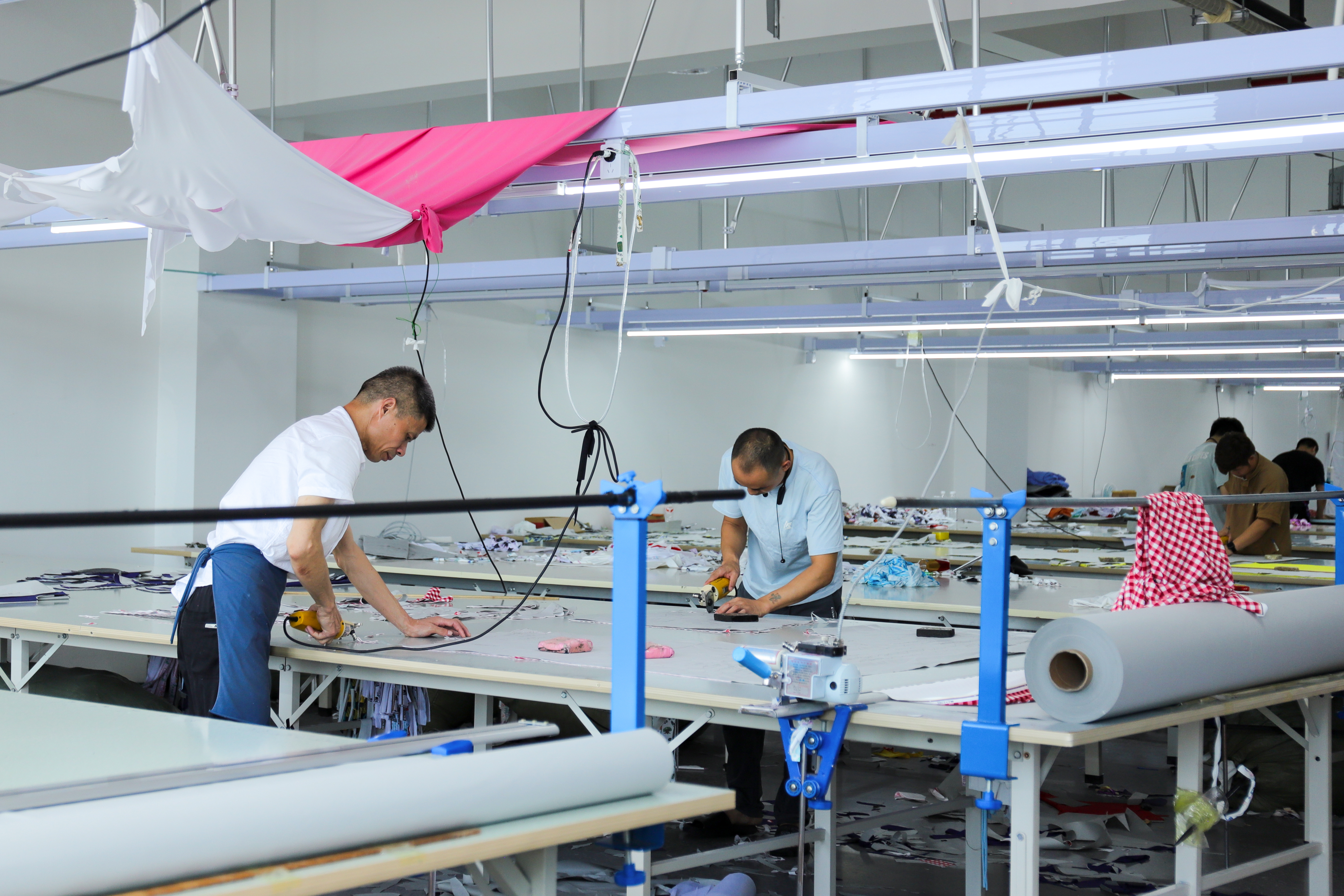 Factory team cutting garment pieces at a cutting table