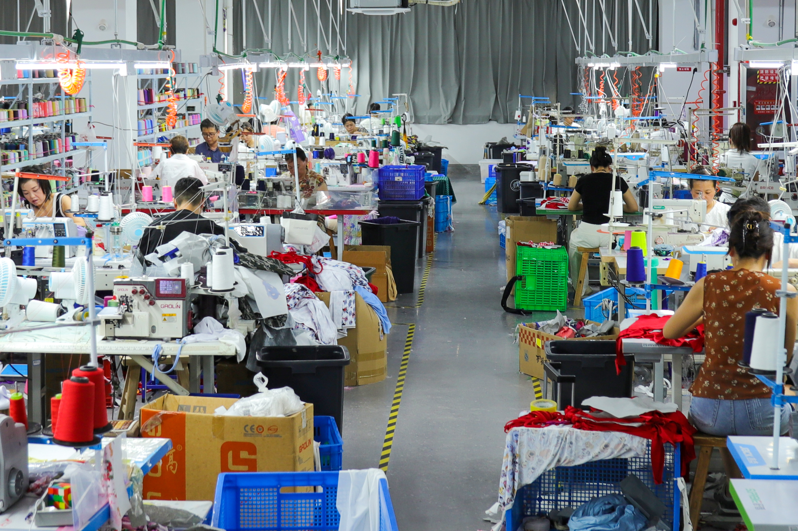 Workers sewing children's garments on a production line